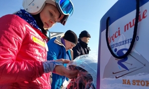 Z lewej strony widać dziewczynkę w kasku narciarskim, z prawej torebkę z nazwą akcji"