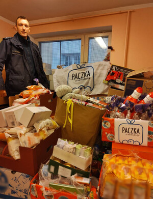 Zdjęcie przedstawia policjanta dzielnicowego organizatora akcji z darami od darczyńców.