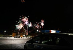 Zdjęcie przedstawia radiowóz a w tle fajerwerki.