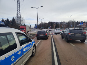 Zdjęcie przedstawia miejsce zdarzenia drogowego - pojazdy uczestniczące oraz policyjny radiowóz.