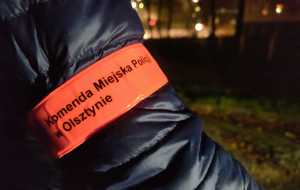 Zdjęcie przedstawia odblask na ręce z napisem &quot;Komenda Miejska Policji w Olsztynie&quot;.