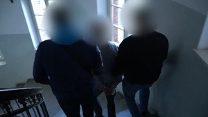 Zdjęcie przedstawia prowadzenie zatrzymanego mężczyzny.