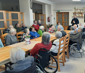 Zdjęcie przedstawia spotkanie z seniorami zorganizowanym przez dzielnicowego.