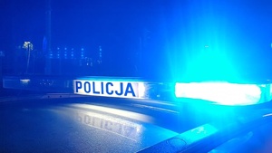 Zdjęcie przedstawia fragment radiowozu nocą.