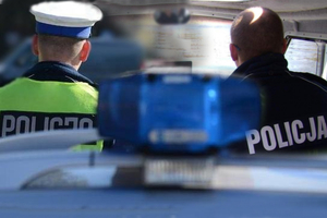Zdjęcie przedstawia policyjny radiowóz i policjantów. Źr. KWP Olsztyn