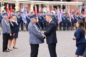 Zdjęcie przedstawia podinsp. Dariusz Koszałkę odbierającego medal od Prezydenta RP