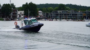 Zdjęcie przedstawia policyjną łódź na jeziorze.