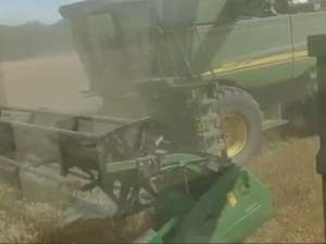 Zdjęcie przedstawia maszynę rolniczą podczas prac polowych.