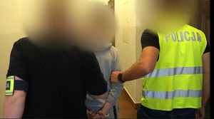 Zdjęcie przedstawia prowadzenie zatrzymanego mężczyzny.