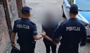 Zatrzymany mężczyzna prowadzony przez policjantów