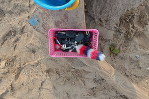 Zdjęcie przedstawia kluczyki w pudełku w piaskownicy.