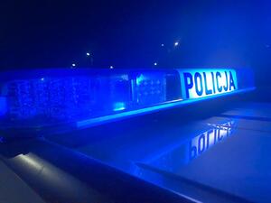 Zdjęcie przedstawia napis POLICJA oraz sygnały świetlne.