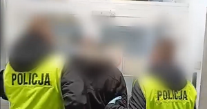 Zdjęcie przedstawia prowadzenie zatrzymanego mężczyzny.