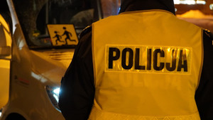 Zdjęcie przedstawia fragment policjanta i autokara
