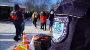 Zdjęcie przedstawia fragment policjanta i uczestników festynu.