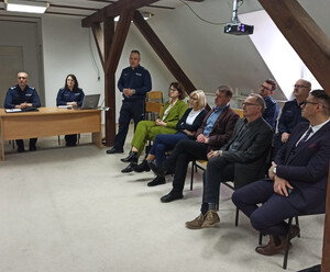 Zdjęcie przedstawia policjantów oraz uczestników odprawy rocznej w Komisariacie Policji w Dobrym Mieście.