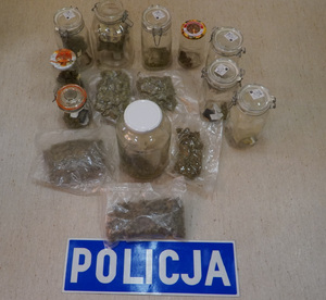 Zdjęcie przedstawia zabezpieczone narkotyki i napis "Policja".