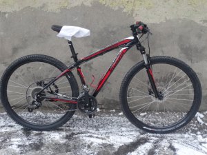 Zdjęcie przedstawia rower koloru czarno-czerwonego.