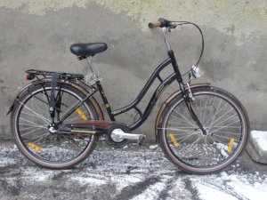 Zdjęcie przedstawia rower koloru czarnego z brązowymi wstawkami.