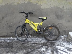 Zdjęcie przedstawia rower koloru żółtego.